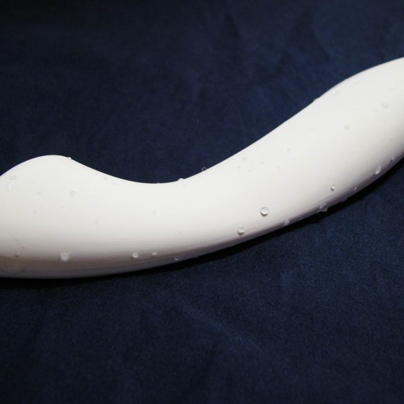 The LELO Ella, a white dildo with a flat tip, lying on a dark blue sheet. It is slightly wet.
