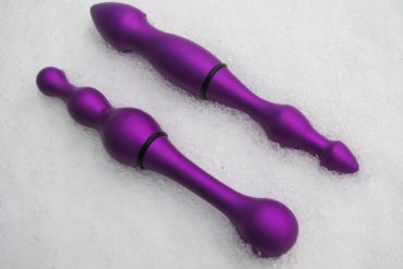 Tantus Alumina Revolve and Motion aluminum dildos lying in the snow.