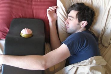 A guy pretending to sleep in bed, with his arm around a Fleshlight mount. Am I supposed to be horrified?