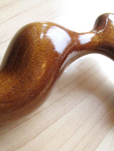 Romp butt plug in gorgeous honey-colored Mora wood.
