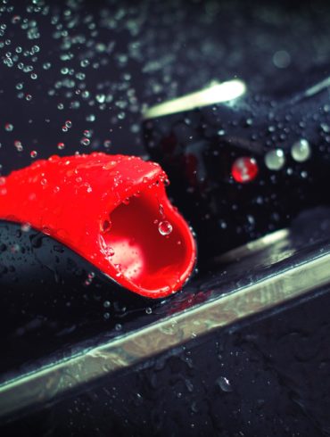 Fun Factory Cobra Libre, looking like a funny car with a weird mouth, getting rained on by droplets of water.