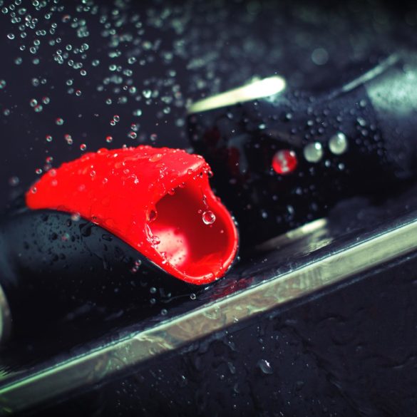 Fun Factory Cobra Libre, looking like a funny car with a weird mouth, getting rained on by droplets of water.
