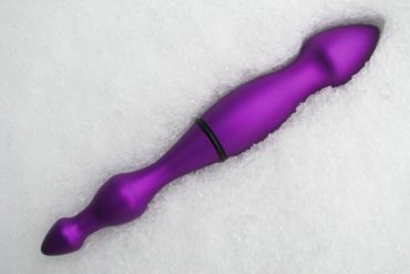 Purple aluminum dildo lying in the snow.