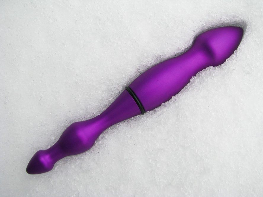 Purple aluminum dildo lying in the snow.