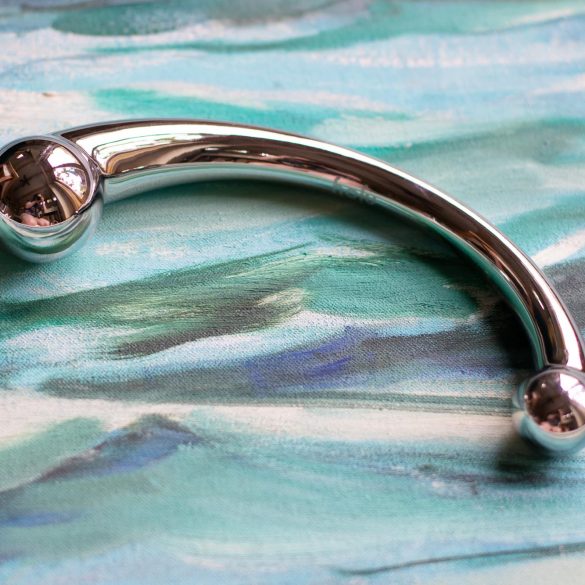 njoy Pure Wand stainless steel G-spot dildo on a painting of the ocean waves.