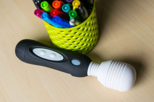 All hail the Vibratex Mystic Wand! On a desk next to a cute container of colorful sharpie pens.