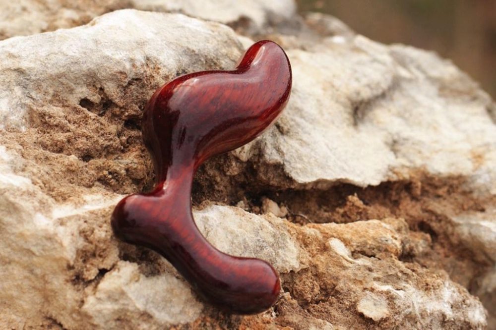 NobEssence Romp anal plug, lying on a craggy rock in the great outdoors.