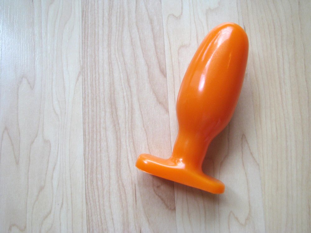 Oh hai, I AM ORANGE. The Tantus Ryder on a wooden floor.