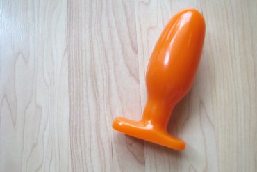 Oh hai, I AM ORANGE. The Tantus Ryder on a wooden floor.