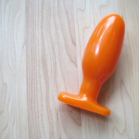 Oh hai, I AM ORANGE. The Tantus Ryder on a wooden floor.