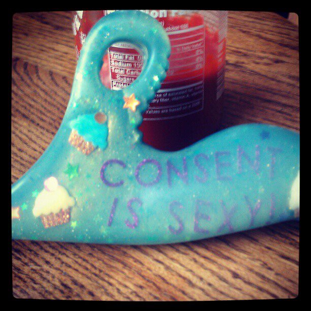 Custom Jollie dildo! It's turquoise and glittery, with cupcakes and the words "CONSENT IS SEXY" embedded in the silicone.
