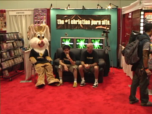 Craig and Mike's booth at a porn convention, where they sit alone with their rabbit friend.