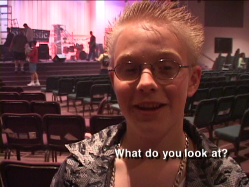 A kid with bleach-blonde spiky hair and a smirk on his face, answering the question "what do you look at?"