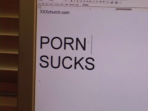 Computer screen with a text file open which reads in a large font, "PORN SUCKS"