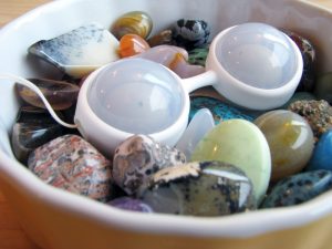 LELO Luna Beads Mini lying in a dish full of colorful stones.