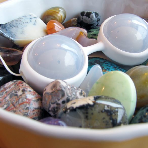 LELO Luna Beads Mini lying in a dish full of colorful stones.