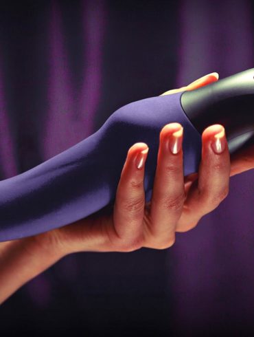Person holding the Fun Factory Stronic Eins in front of a curtain.