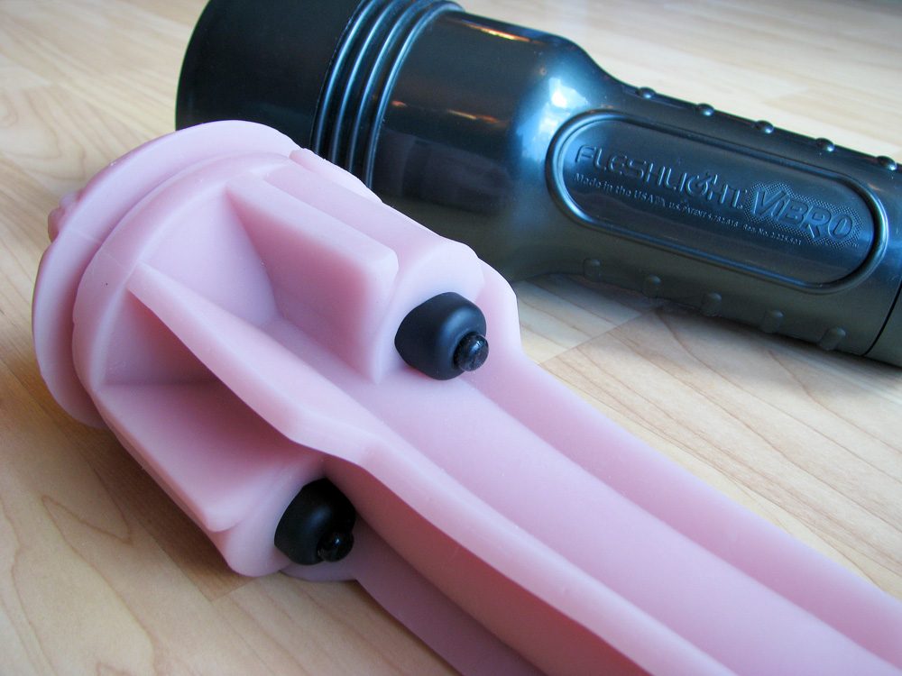 Fleshlight Vibro sleeve out of its case, showing the bullet vibrators nestled into pockets of the sleeve.