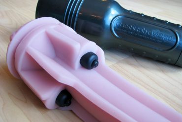 Fleshlight Vibro sleeve out of its case, showing the bullet vibrators nestled into pockets of the sleeve.