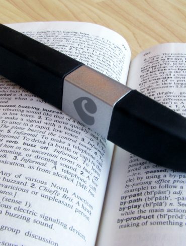 Lovehoney Flash USB rechargeable vibrator on top of a dictionary, open to the definition of "buzzy."