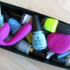LELO Ida vibrator in a box of various nail polishes.