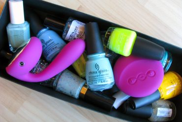 LELO Ida vibrator in a box of various nail polishes.