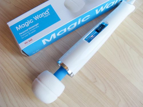 Hitachi Magic Wand Original and its box, on a hardwood floor.