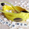 Magic Banana kegel exerciser and dildo, surrounded by plastic letters from the Bananagrams game spelling out "EMPOWERMENT."
