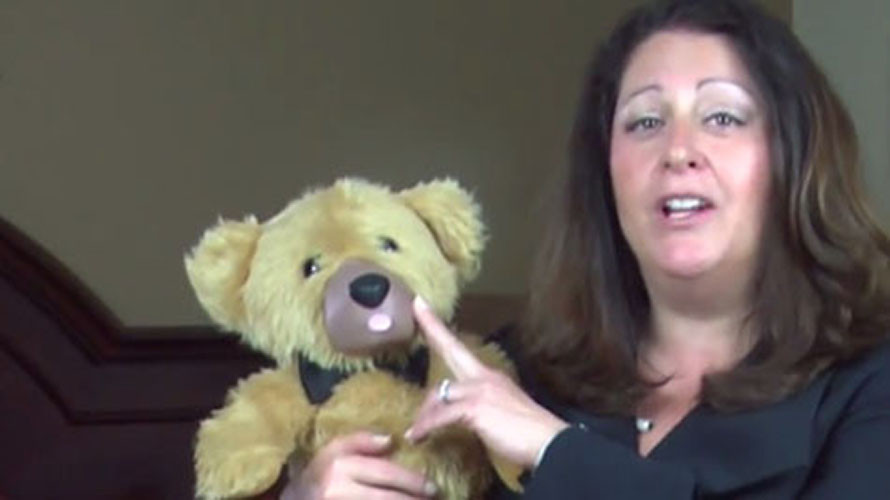 Screenshot from the now-defunct Teddy Love crowdfunding video, of a woman touching a teddy bear's nose.