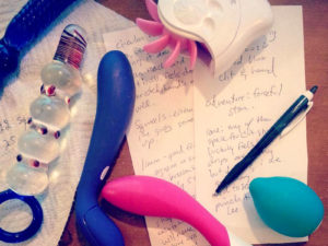 Sex toy masturbation session note taking, with dirtied toys lying on top.