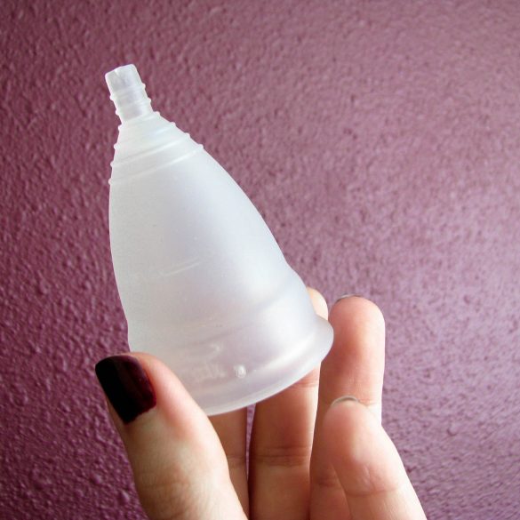 Me holding the Diva Cup silicone menstrual cup, with appropriately blood-colored polish on my fingernails.