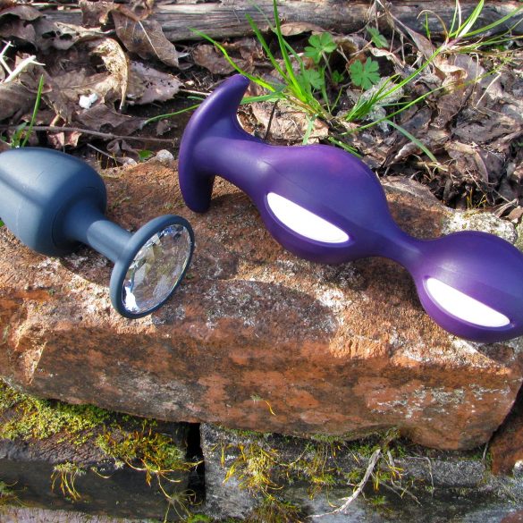 Marc Dorcel Geisha Plug and Fun Factory B Balls kegel ball anal plugs on a moss-covered brick, among leaves.