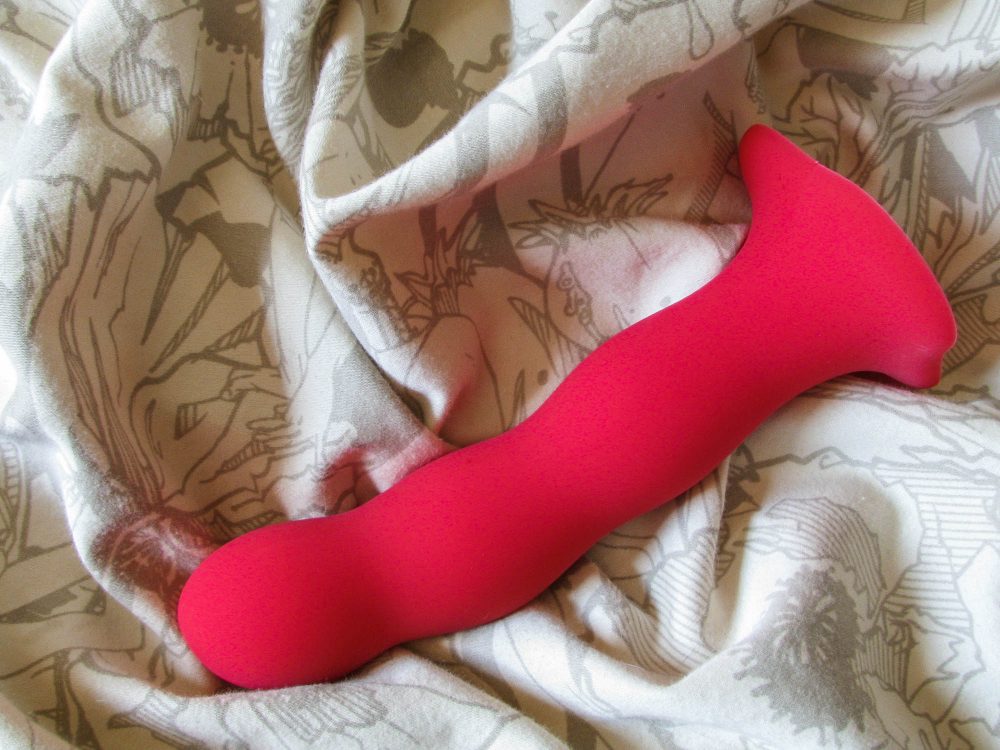 Fun Factory Bouncer kegel ball dildo on an off-white crumpled sheet.