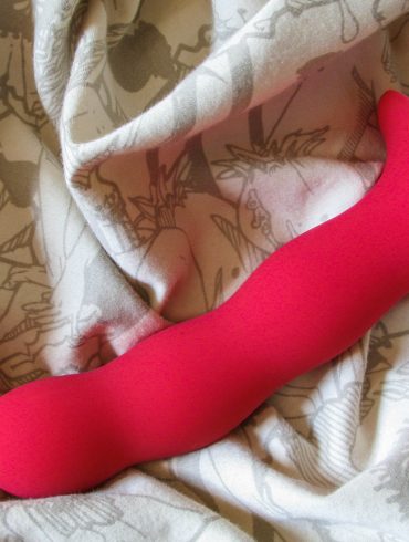 Fun Factory Bouncer kegel ball dildo on an off-white crumpled sheet.