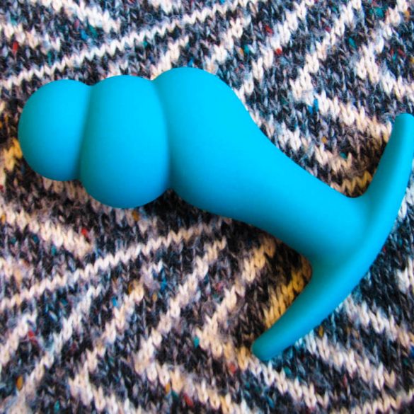Fun Factory Boosty butt plug on a striped black and white fabric.