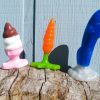 Hole Punch Toys Ass Cram Cone, Plugs Bunny, and Crotch Rocket standing on a wood pile in front of a pale blue house.