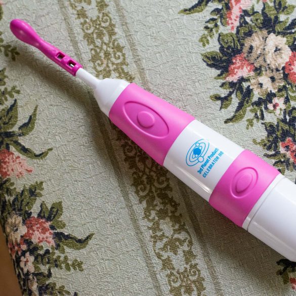 My Celebrator oscillating toothbrush vibrator on a vintage floral patterned surface.