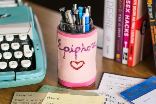 Typewriter, cup of pens, and some sex books. The sparkly "Epiphora" drink cozy on the cup was a gift from Bianca (TheVenusEmporium on Etsy). The other side has a vulva on it!