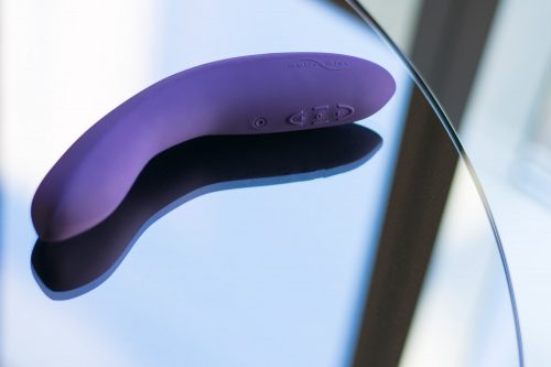 We-Vibe Rave rechargeable app-compatible G-spot vibrator on a reflective table.