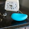 We-Vibe Wish rechargeable clitoral vibrator on a small table, next to a clock and necklace.