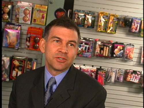 Scott Tucker, president of Topco Sales, backed by a wall of sex toys.