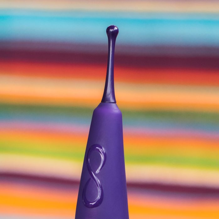 Zumio X rechargeable clitoral vibrator, on a colorful striped blanket.