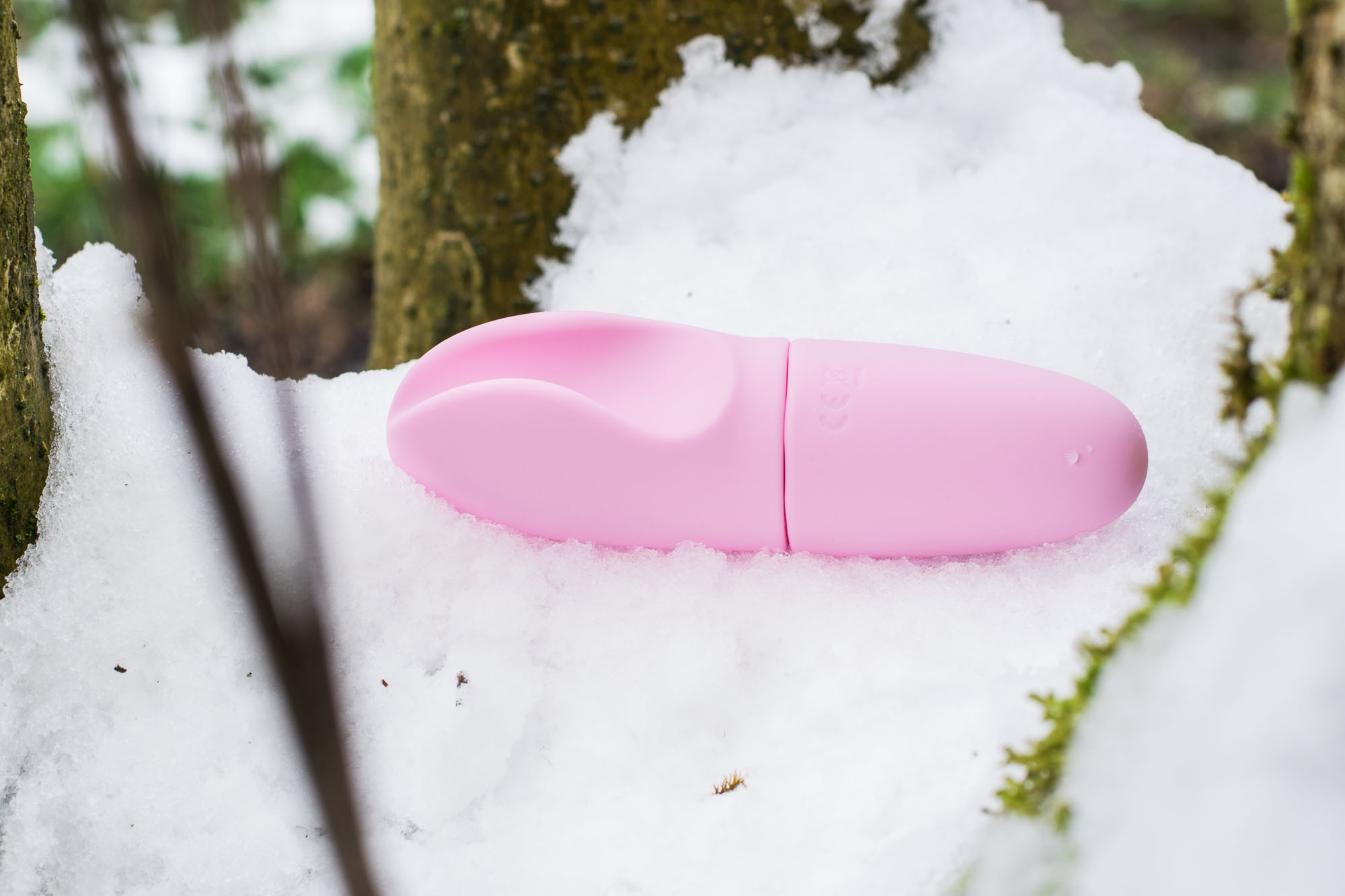 Tickler Toyfriend Smooth Operator Snazzy, a pink vibe resembling a vulva, sitting in the snow.