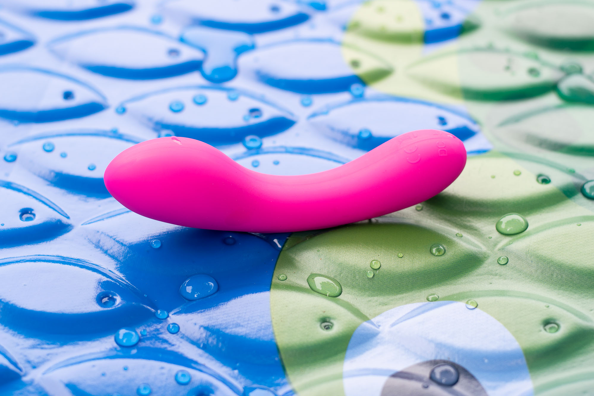 BMS Factory Mini Swan Wand vibrator in a kiddie pool, with droplets of water around.