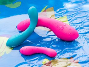 BMS Factory Swan Wand vibrator and its reflection, in shallow water in a kiddie pool.