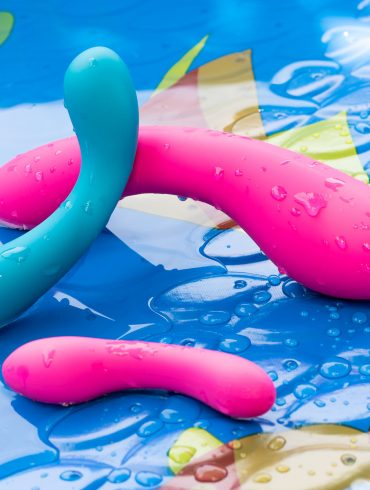 BMS Factory Swan Curve vibrator leaning against the Swan Wand, with Mini Swan Wand in foreground, in a kiddie pool.