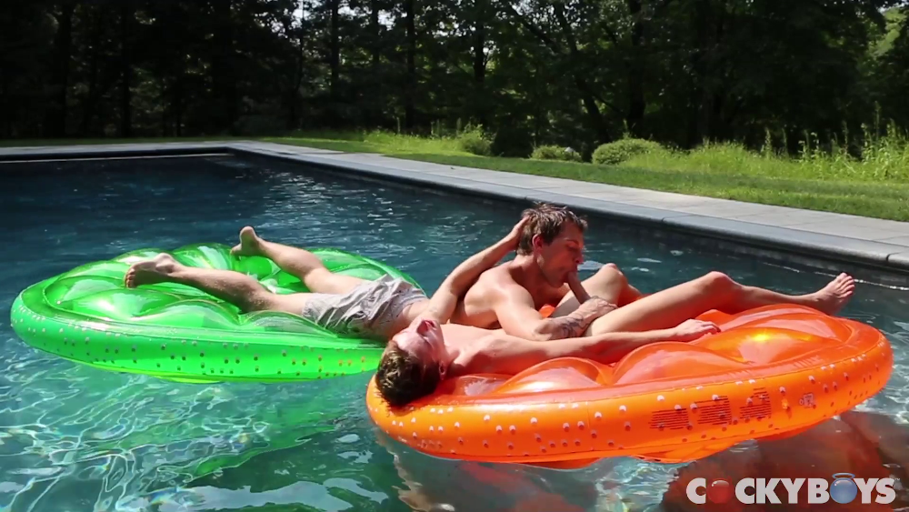 Damian Black and Tayte Hanson canoodling in a pool, on top of lime- and orange-shaped floaties.