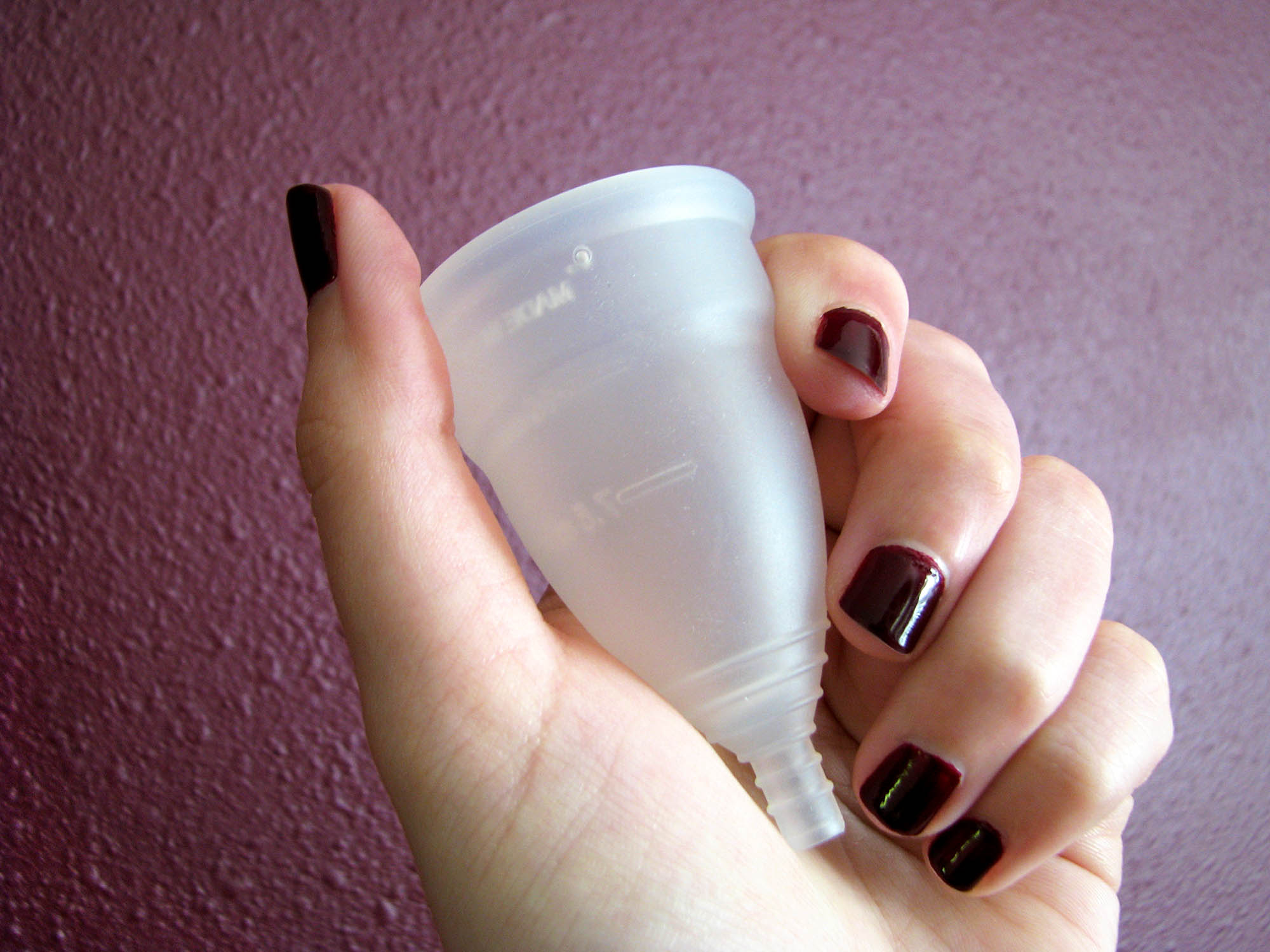 Me holding the Diva Cup silicone menstrual cup, with appropriately blood-colored polish on my fingernails.