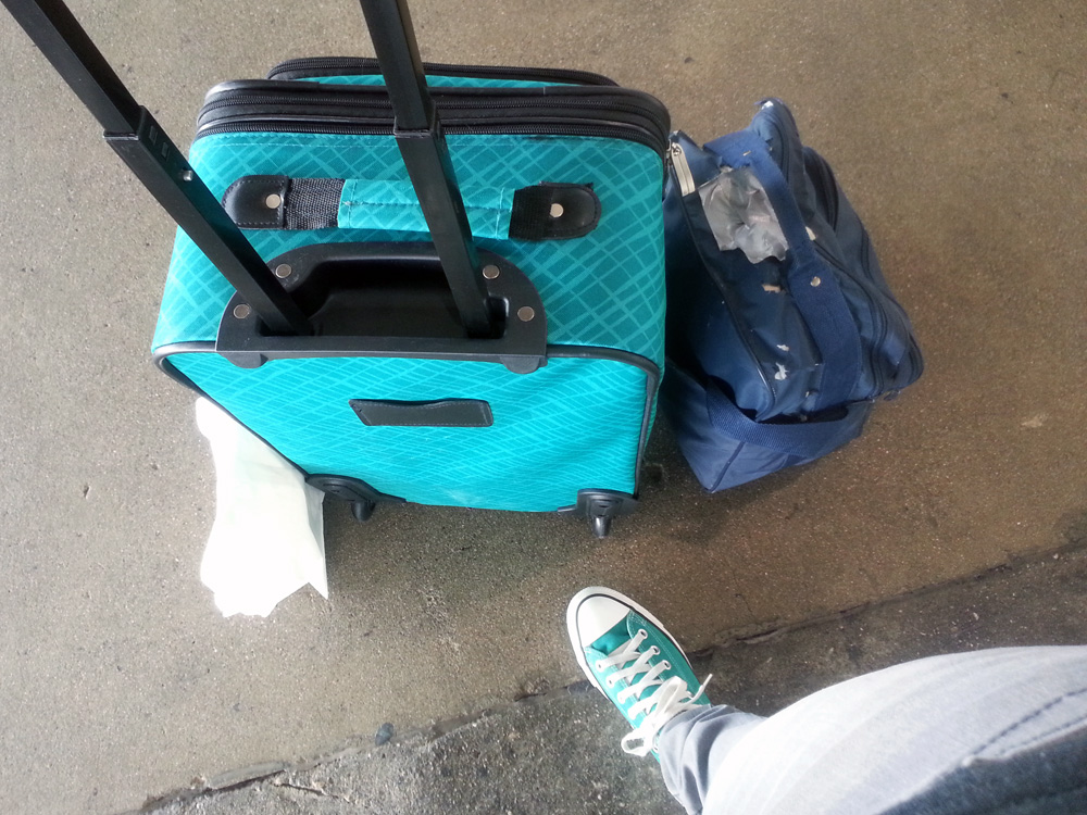 Waiting for the shuttle at the airport with my turquoise suitcase and turquoise Converse.