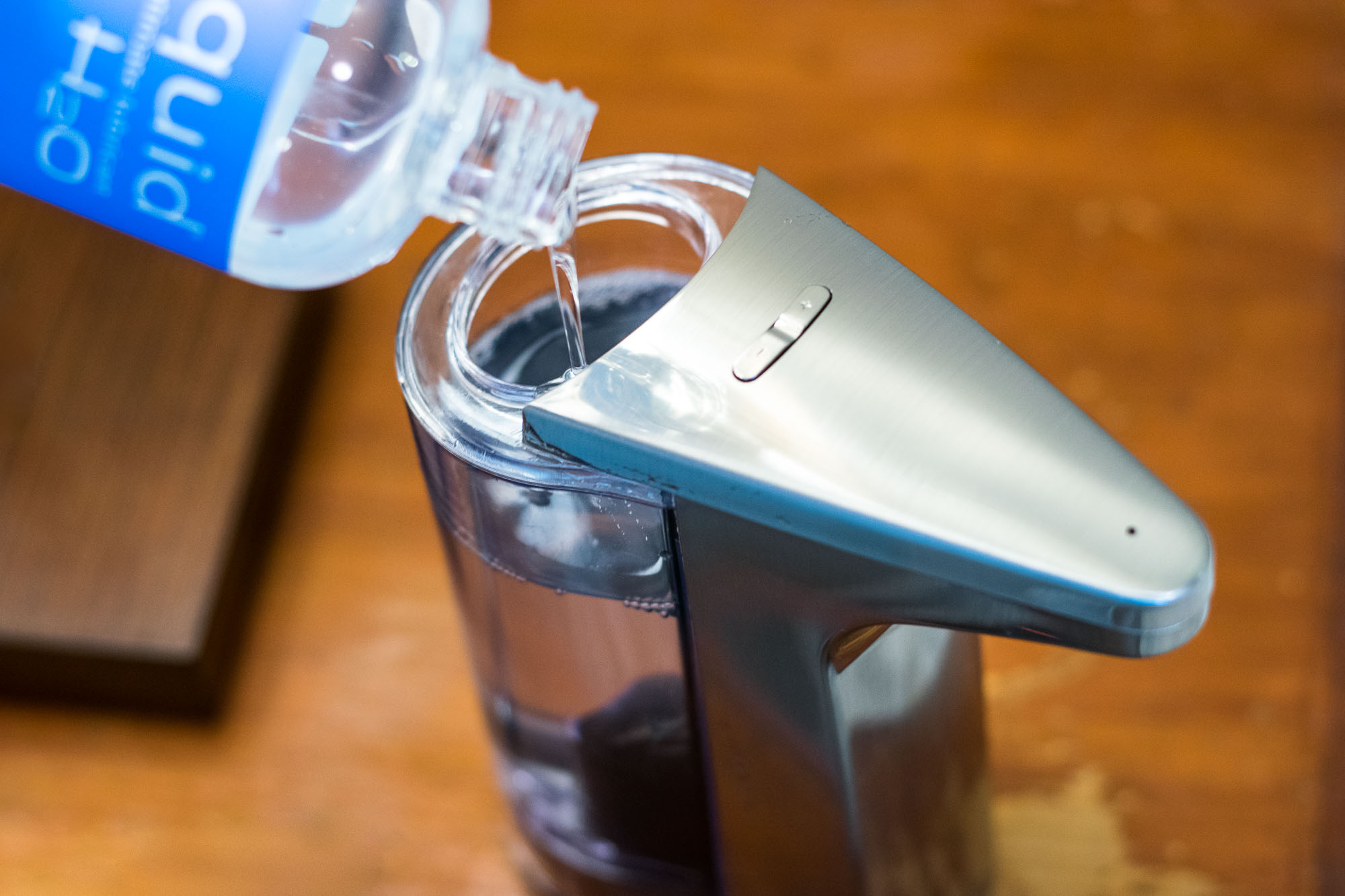 Pouring Sliquid H2O lube into the simplehuman Sensor Pump automatic dispenser.